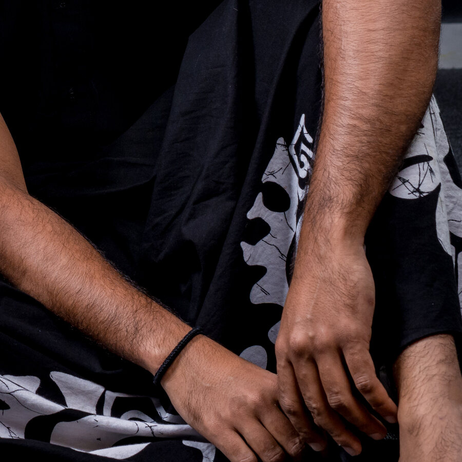 Hands resting on a batik sarong