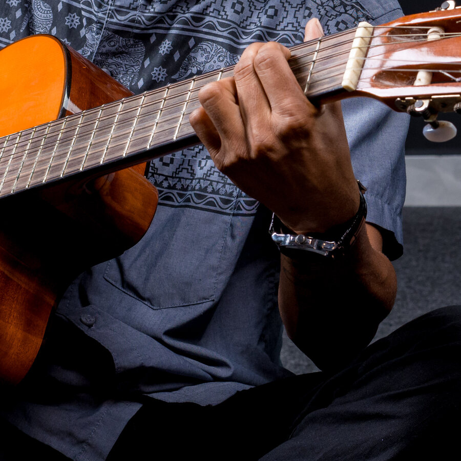 A hand on the guitar fretboard
